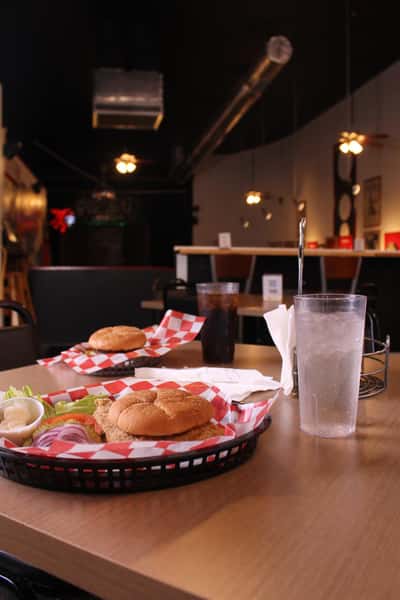 fried chicken sandwich with hamburger and cola in back