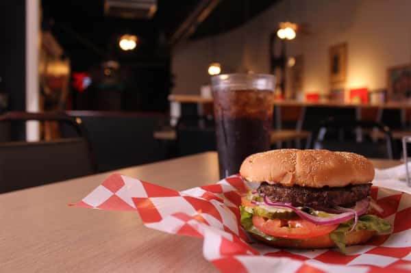 hamburger with cola in background