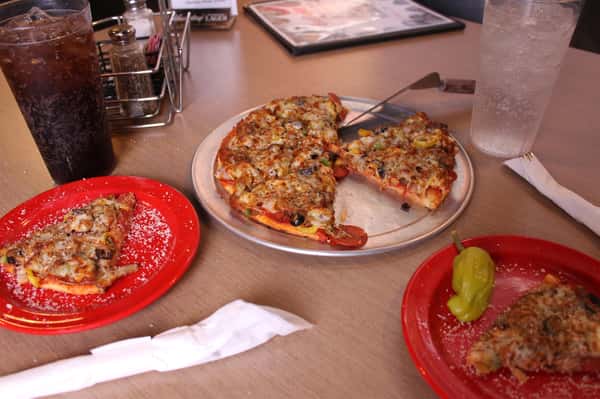 pizza pie with slices on plates