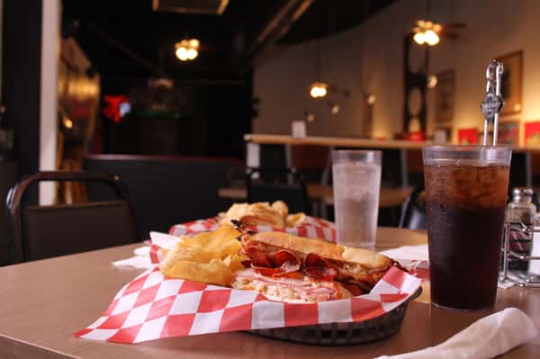 pepperoni hero with chips in a basket with cola and water