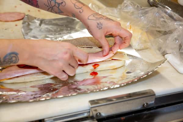 Kitchen prep with hands shaping fresh pizza dough at The Gaslight Pizza & Grill in Huntingburg, Indiana