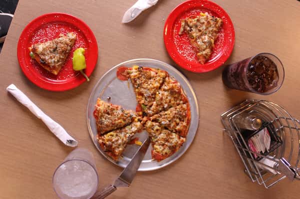 pizza pie with slices on plates