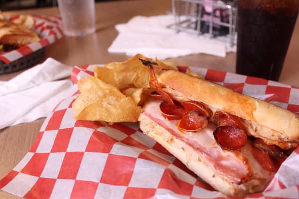 pepperoni hero with chips in a basket with cola and water