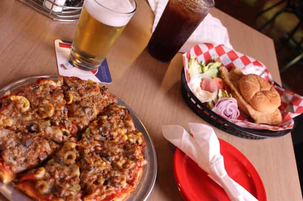 pizza pie with cola and beer with fried chicken sandwich