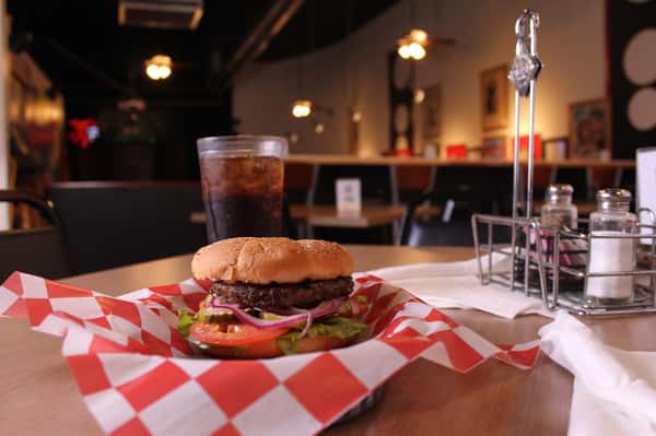 hamburger with cola in background