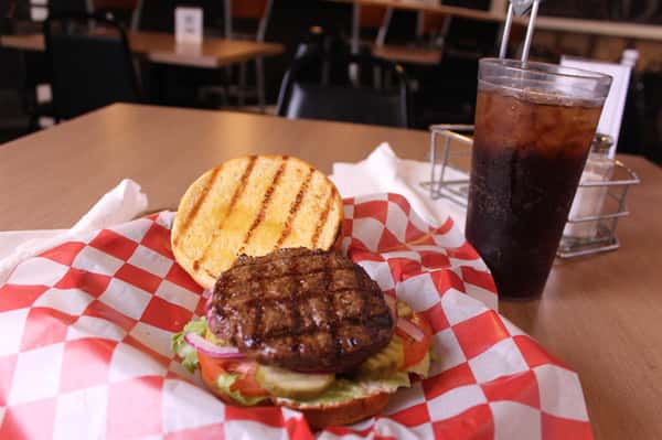 hamburger with cola in background