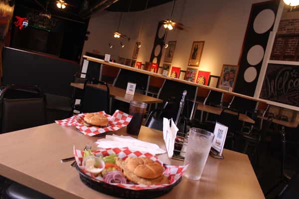 fried chicken sandwich with hamburger and cola in back