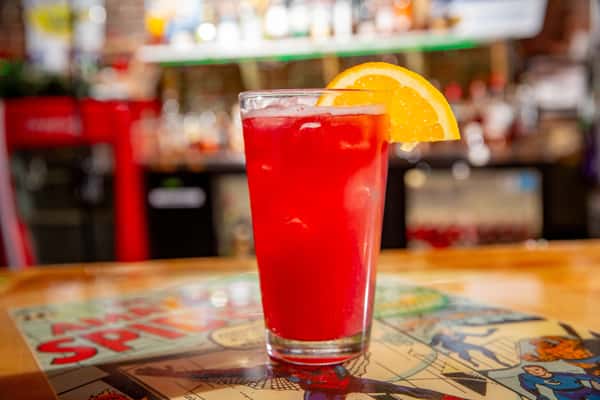 Bright red cocktail with orange garnish at the bar inside The Gaslight Pizza & Grill in Huntingburg, Indiana