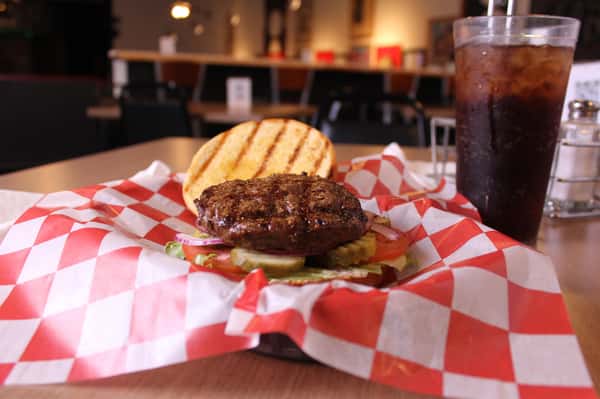 hamburger with cola in background