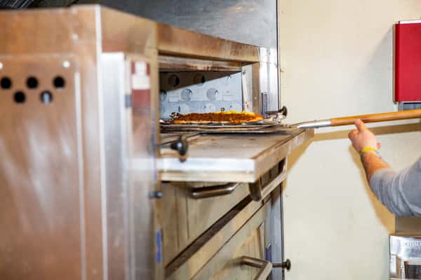 Pizza baking in a commercial oven inside The Gaslight Pizza & Grill kitchen in Huntingburg, Indiana
