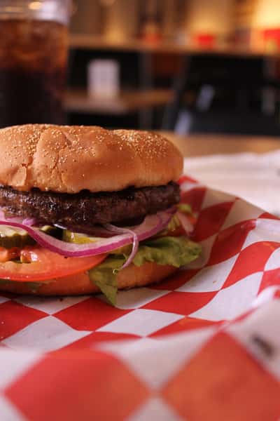 hamburger with cola in background