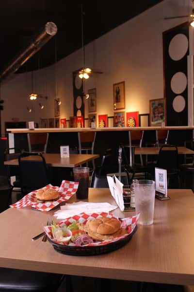 fried chicken sandwich with hamburger and cola in back