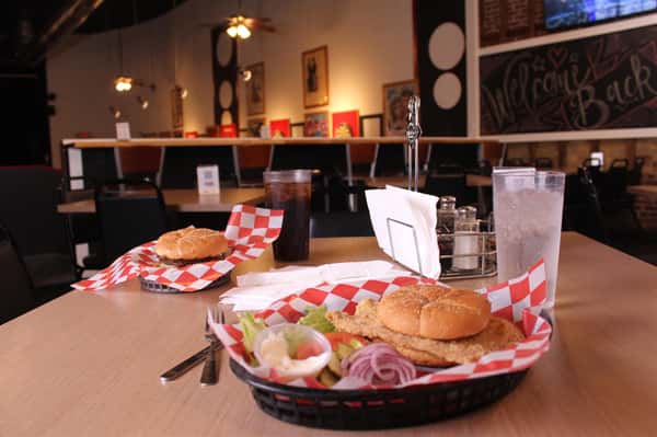 fried chicken sandwich with hamburger and cola in back