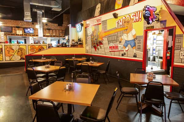 Dining room with tables, wall murals, and casual seating at The Gaslight Pizza & Grill in Huntingburg, Indiana