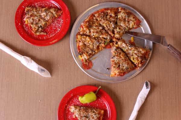 pizza pie with slices on plates