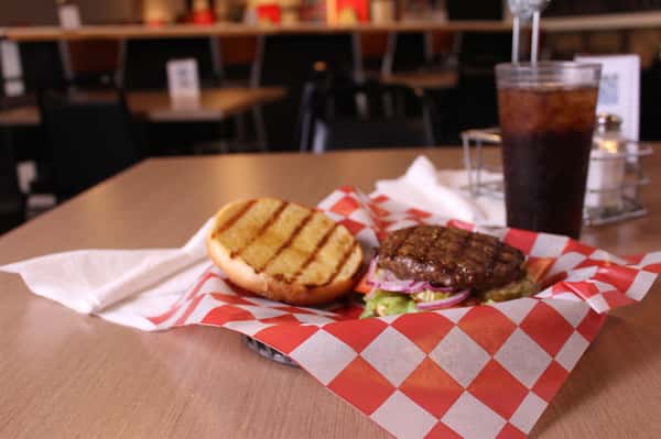 hamburger with cola in background