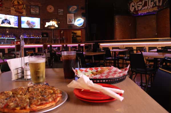 pizza pie with cola and beer in front of stage