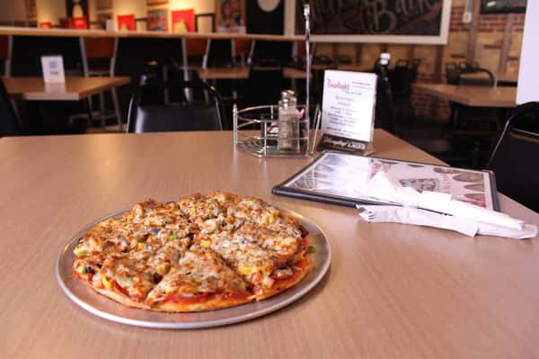 pizza pie with utensils and menu