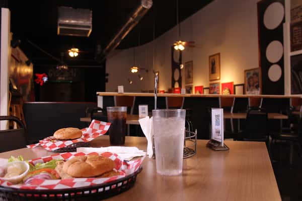 fried chicken sandwich with hamburger and cola in back