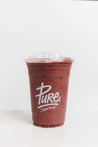 Vibrant red superfood smoothie from Pure Superfoods served in a clear takeaway cup, made with blended berries and nutrient-rich ingredients.