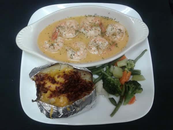 Six large shrimp sauteed in garlic butter sauce with a baked potato and vegetables on the side.