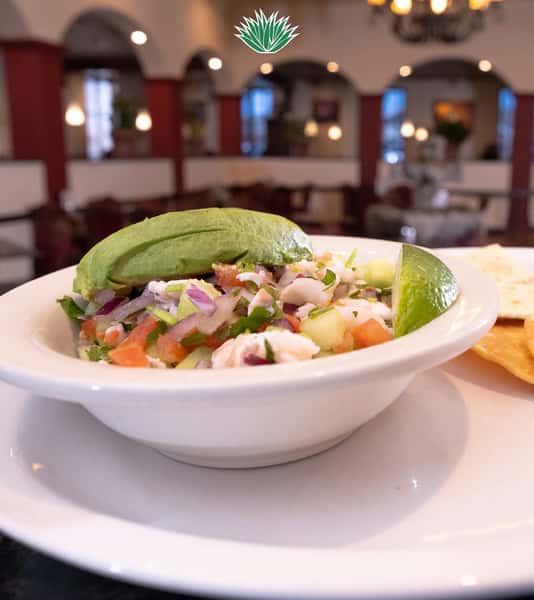 Fresh shrimp ceviche topped with sliced avocado and diced vegetables