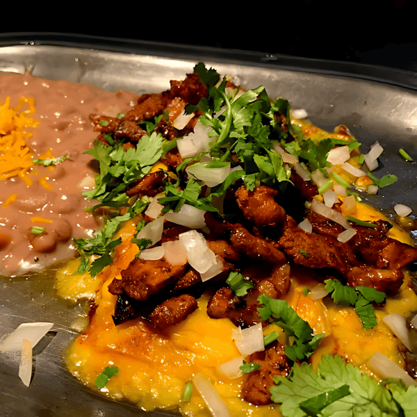Cheesy enchilada topped with grilled meat, onions, and cilantro, served with refried beans and shredded cheddar.