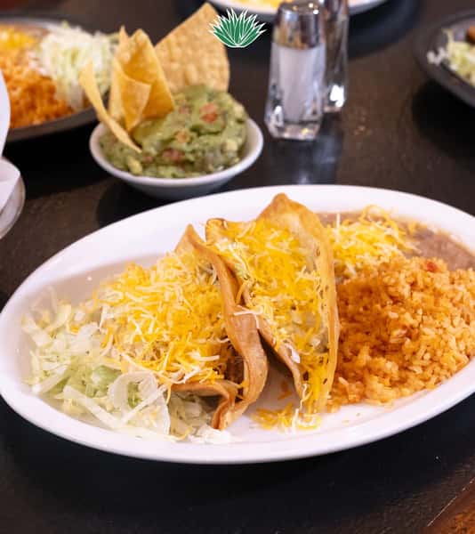 Crispy tacos served with Mexican rice and refried beans