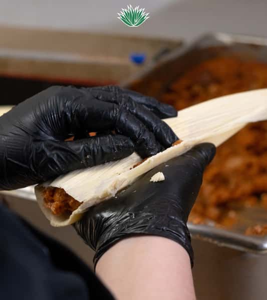 Fresh tortilla being prepared by hand on a wooden surface