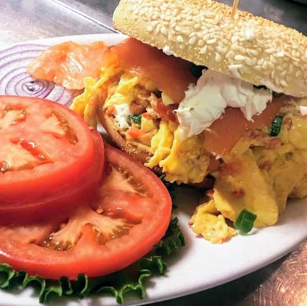 Lox, egg and onion scramble open face on a toasted bagel smothered with lox