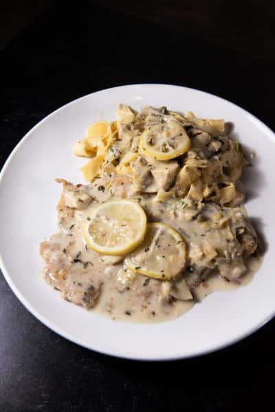 A white dish with pasta and chicken