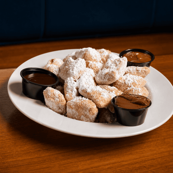 Powdered sugar beignets served with chocolate dipping sauces