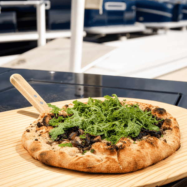 Flatbread pizza topped with fresh arugula