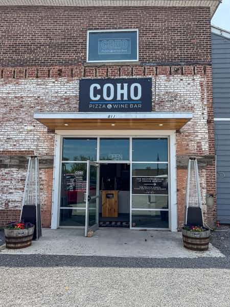 Exterior storefront entrance of COHO Pizza & Wine Bar with brick facade