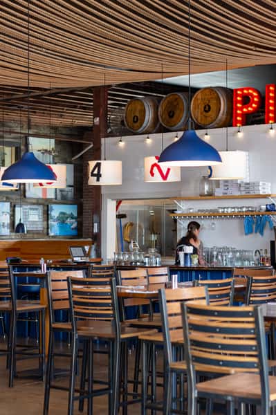 Restaurant bar area with wooden high-top tables and string lighting