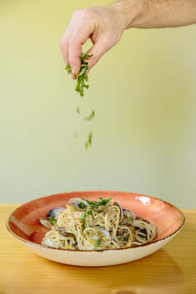 pasta with hand sprinkling garnish