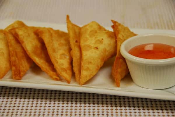 Crispy golden wontons arranged on a rectangular plate, paired with a small ramekin of sweet chili dipping sauce, perfect for Asian appetizer offerings.