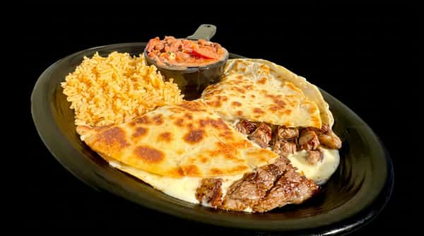 Carne Asada Quesadilla with rice and a side of red salsa, served on a black plate.
