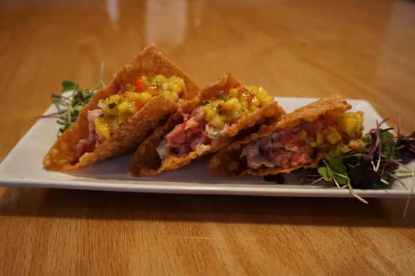 Three light wonton shells filled with sushi grade tuna in a miso vinaigrette, maple soy reduction & topped with mango salsa and wild arugula on the side