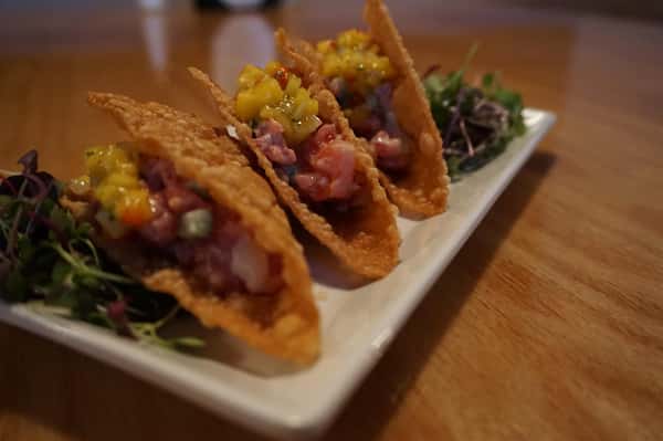 Three light wonton shells filled with sushi grade tuna in a miso vinaigrette, maple soy reduction & topped with mango salsa and wild arugula on the side