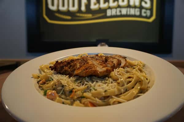 Linguine topped with grilled chicken and parmesan cheese