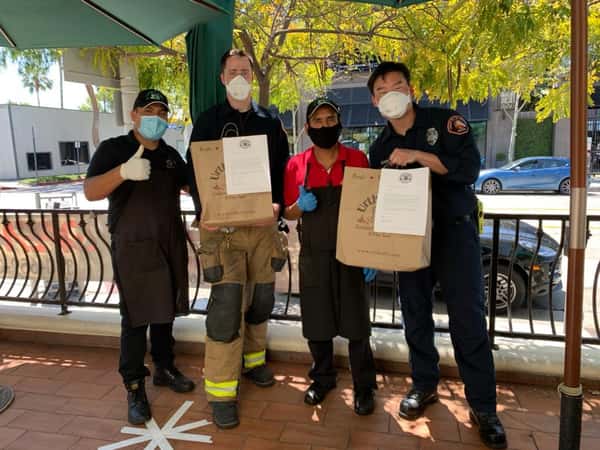 2 Urth Melrose employees with 2 Firemen holding Urth shopping bags and