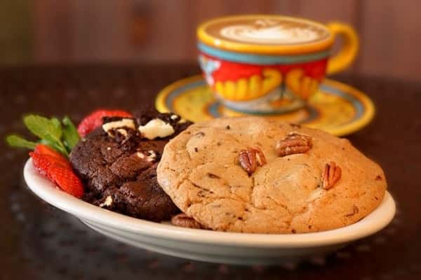 Home-Made Goodies, Baked to Perfection. It's National Cookie Month! Celebrate the occasion by enjoying fresh baked classic cookies at your nearest Urth Caffé!
The Love Chocolate Chunk is soft, moist & loaded with big chunks of the finest Swiss chocolate that is sure to make you fall in love with every bite! For a mix of crunchiness and sweetness, try the Chocolate Chunk Pecan Cookie which includes not only the finest chocolate but also sizeable amounts of pecan.
Can't get enough chocolate? The Triple Chocolate Chunk is a dream come true for chocolate lovers; our delicious chocolate cookie is made with semi-sweet dark and white chocolate. Lastly, but not least, is the Oatmeal-Raisin Cookie made with organic oatmeal, raisins and flavored with cinnamon to give a warm, cozy finish for a long Fall Day.
Also available is our Vegan* Chocolate Chunk Pecan Cookie and Vegan** Oatmeal-Raisin Cookie, egg & dairy free for all to enjoy!
**We cannot guarantee that our vegan items have not been prepared with non-vegan items.
#urthcaffe #nationalcookiemonth #richchocolate #homemaderecipes #organicingredients