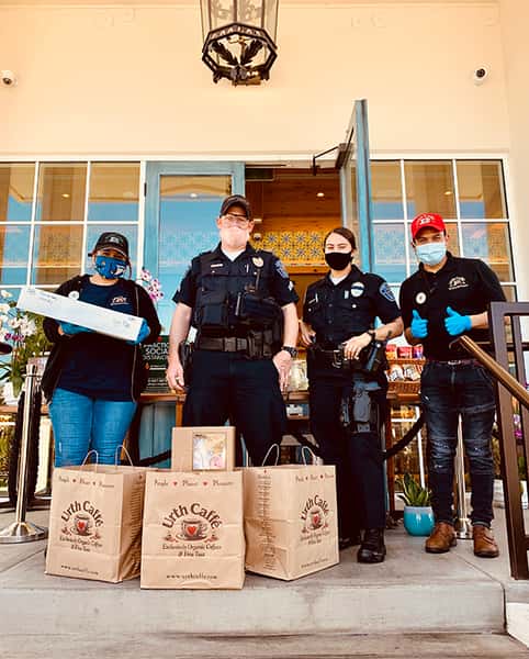 Male and Female Hawthorne Police with two Urth employees on Urth South Bay entrance with Urth bags and lunch boxes