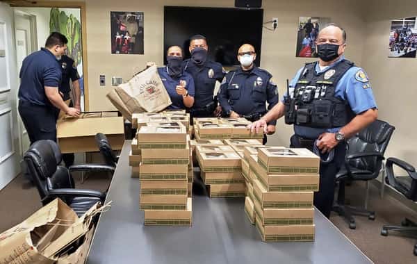 Five Pasadena police standing around conference table stated with Urth Lunch boxes.
