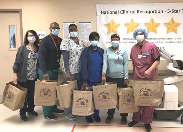 Six nurses in a line holding Urth food bags