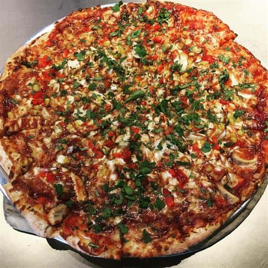 B B Q Chicken pizza. Mozzarella, grilled chicken, BBQ sauce, roasted red peppers, onions, corn and fresh cilantro.