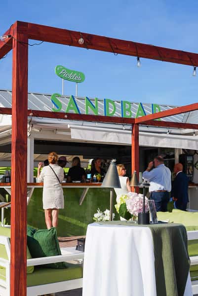 Restaurant entrance with the Sandbar sign welcoming guests to a vibrant waterfront dining destination.