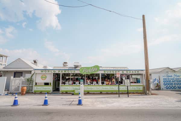 Exterior view of a beachfront restaurant with outdoor seating and coastal charm near the shoreline.