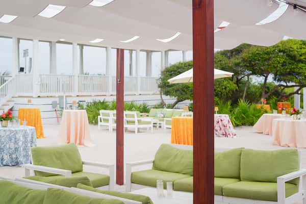 Open-air rooftop patio with comfortable lounge seating, pergolas, and waterfront views, offering a relaxed outdoor dining experience.
